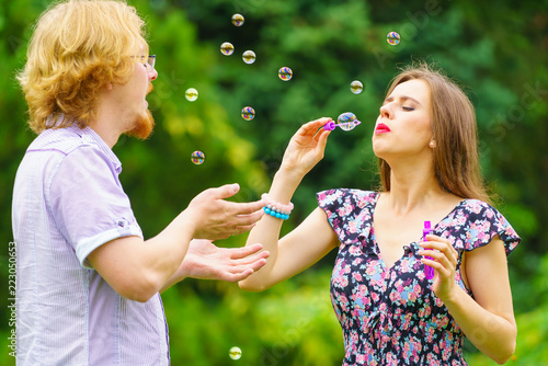 Couple blowing soap bubbles  having fun