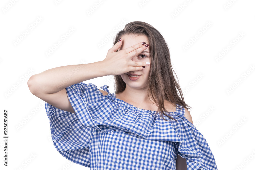 Beautiful girl closes her eyes with her palm and peeks through her fingers, isolated on white background Beautiful girl closes her eyes with her palm and peeks through her fingers, isolated on white background