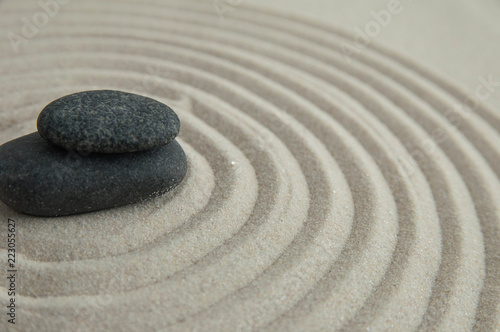 Pyramids of gray zen stones on the sand with wave drawings. Concept of harmony  balance and meditation  spa  massage  relax