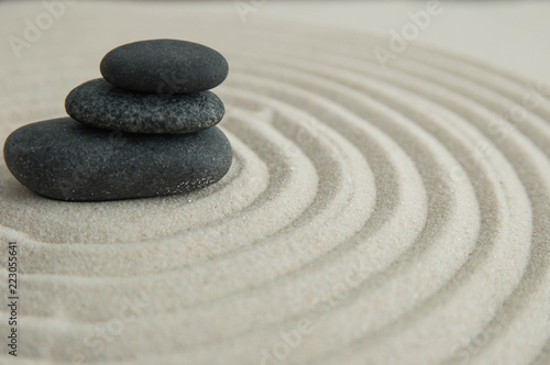 Pyramids of gray zen stones on the sand with wave drawings. Concept of harmony  balance and meditation  spa  massage  relax