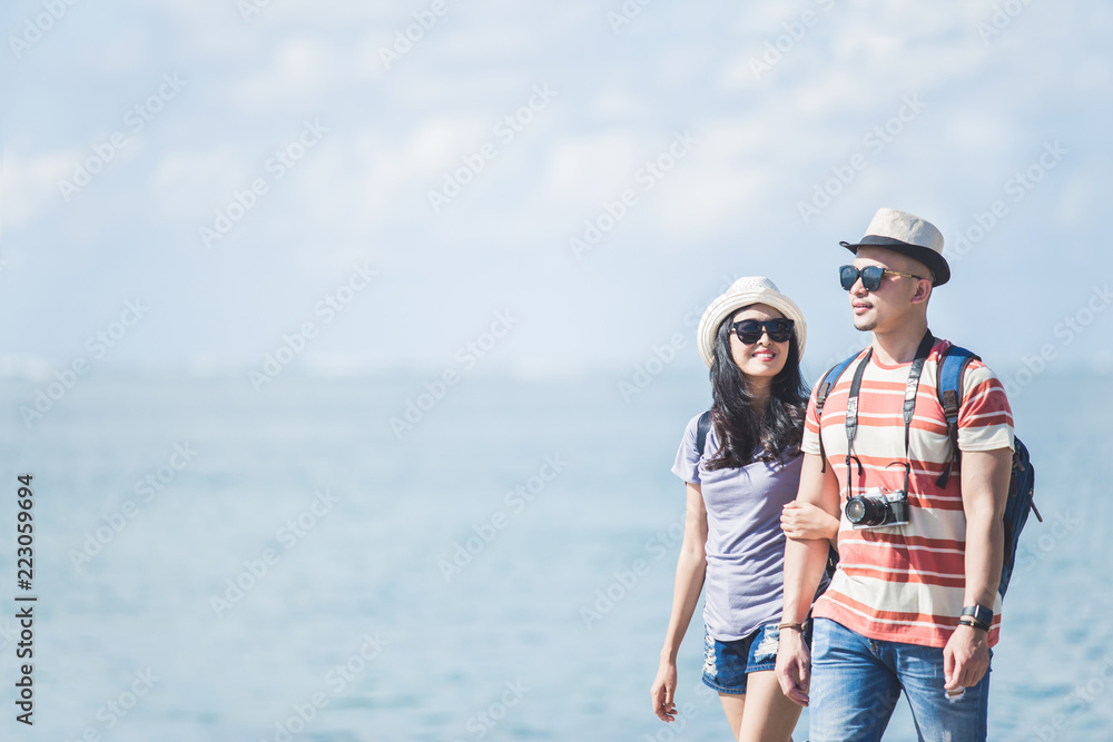 backpackers couple wearing summer hat and sunglasses walking on 