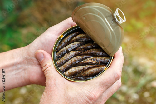 Can with sprats in hand