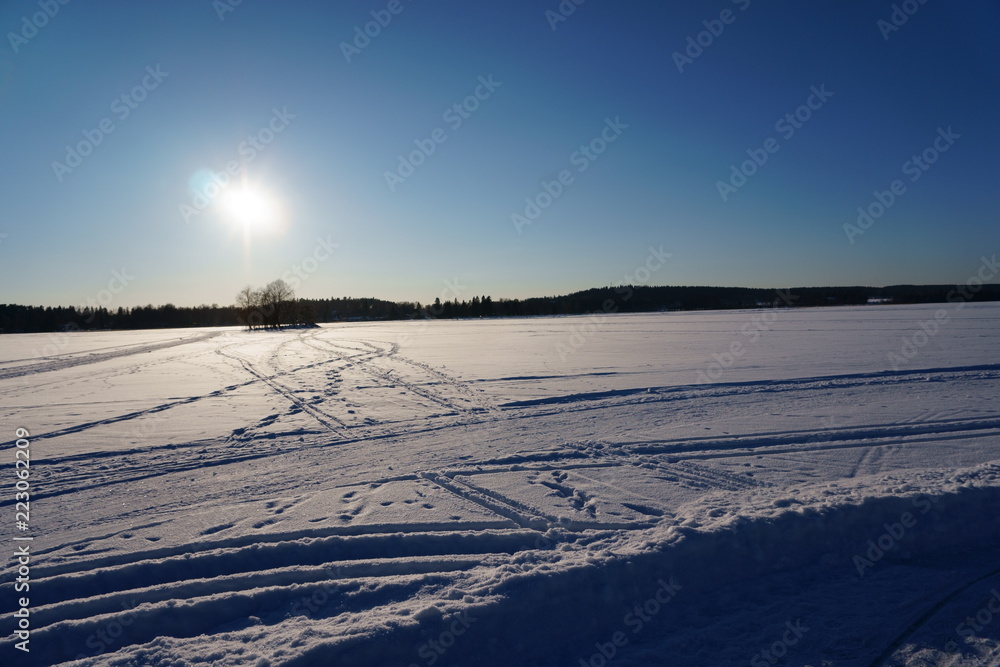 Winter landscape with lake, island and sky
