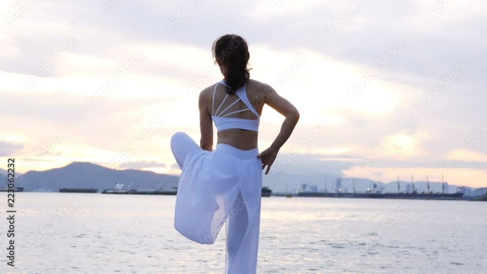 Young asian woman practicing yoga at outdoor place. beautiful woman doing yoga in the beautiful sky with sunrise background. Young asian woman practicing yoga at outdoor place. beautiful woman doing yoga in the beautiful sky with sunrise background.