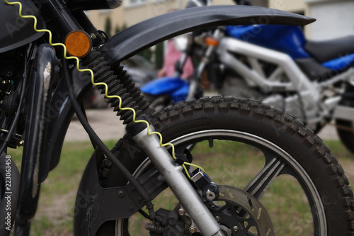 Detail of the motorcycle. View of the front wheel of the motorcycle with a tire for off-road driving.