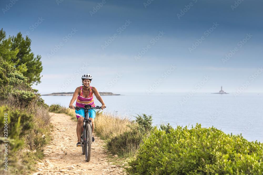 Fototapeta premium Kroatien, Istrien, Pula, Kap Kamenjak, Mountainbiker auf dem Trail am Meer