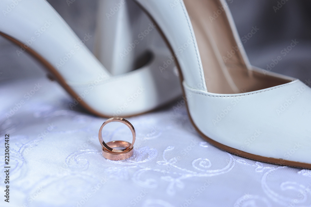 Beautiful wedding ring on the bride's white shoes Beautiful wedding ring on the bride's white shoes