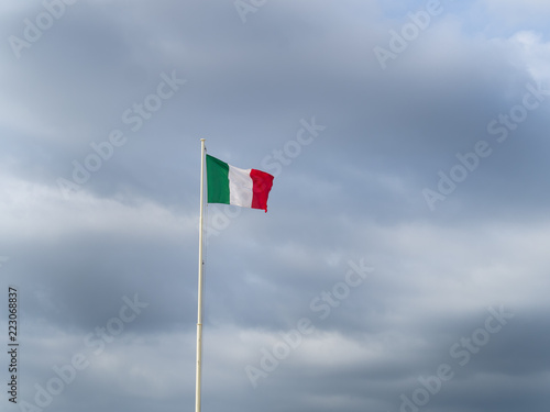 Flag of Italy republic waving in the wind, cloudy background