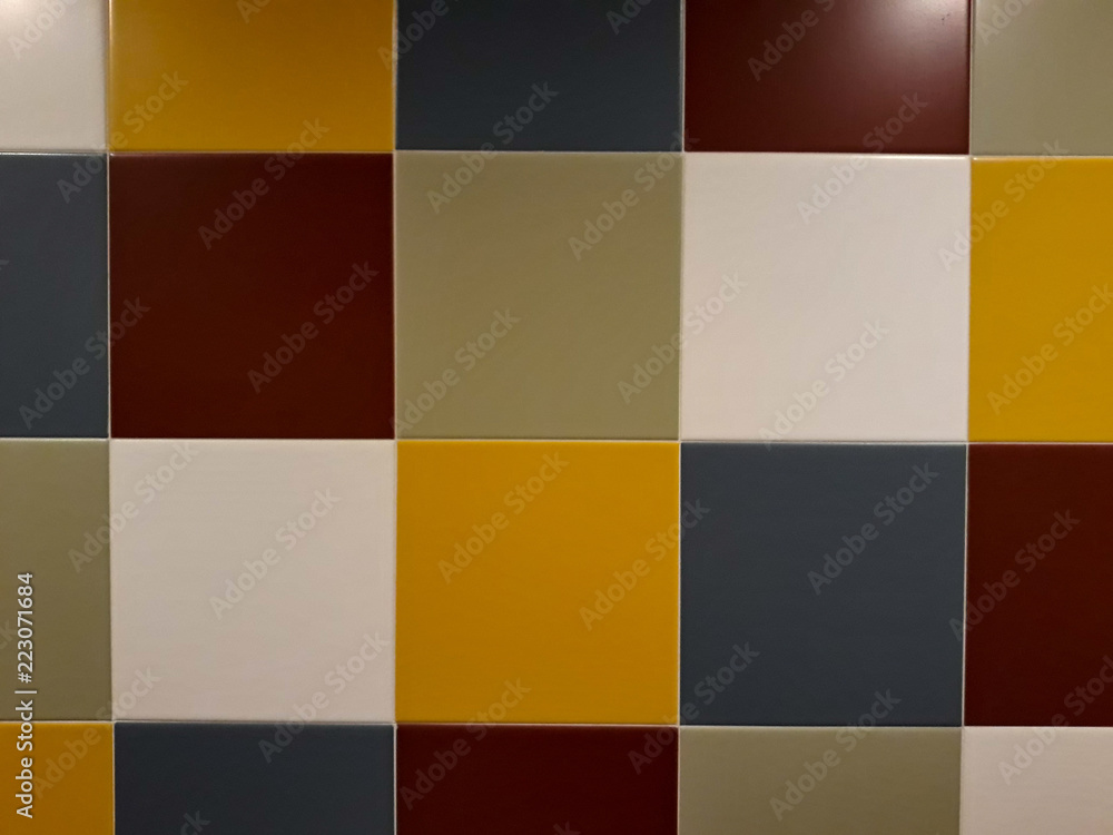 Square tiles in yellow, green, red, grey on wall for backgrounds