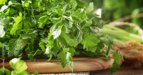 Fresh green parsley in bunch, old wooden table, selective focus