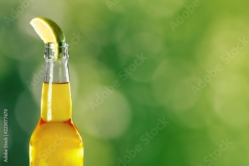 Cold beer with lime on background
