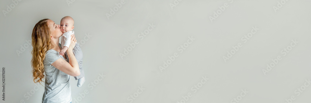 Mother holding her newborn child. Woman and infant boy relax and playing on white background. Mom of breast feeding baby. Family, maternity, tenderness, parenthood, responsibility concept. Banner - obrazy, fototapety, plakaty 