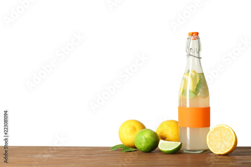 Bottle with natural lemonade on table against white background