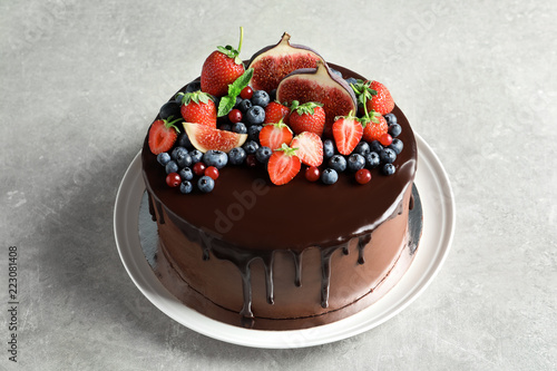 Fresh delicious homemade chocolate cake with berries on gray table