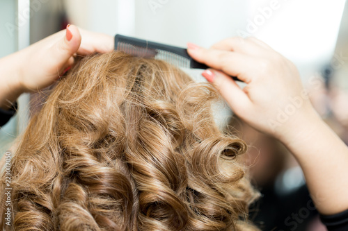 Girl combing her hair without looking at the camera
