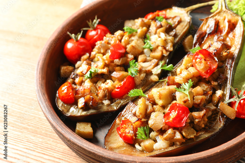 Bowl with tasty stuffed eggplants on wooden table, closeup Bowl with tasty stuffed eggplants on wooden table, closeup