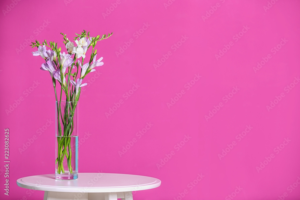 Obraz premium Beautiful fragrant freesia flowers in vase and space for text on color background