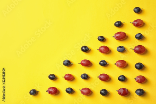 Fresh ripe juicy grapes on yellow background  top view. Space for text