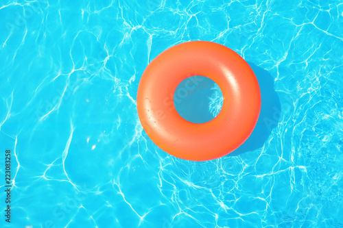 Inflatable ring floating in swimming pool on sunny day, top view