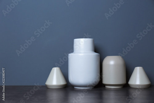 Beautiful ceramic vases on table against color wall with space for text © New Africa