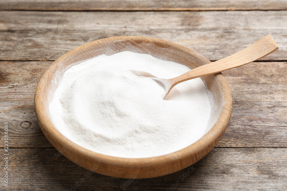 Plate with baking soda on wooden background Plate with baking soda on wooden background