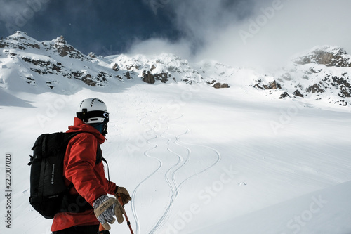 Fotografie Skier watches ski tracks in British Columbia backcountry