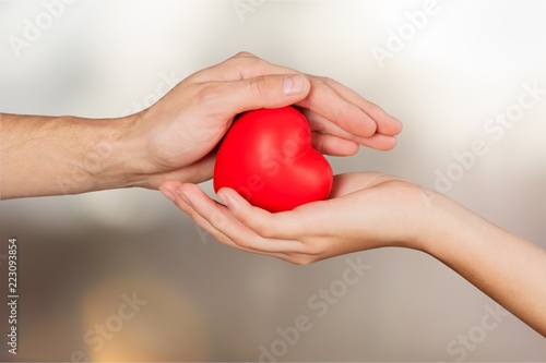 Man and woman holding red heart in