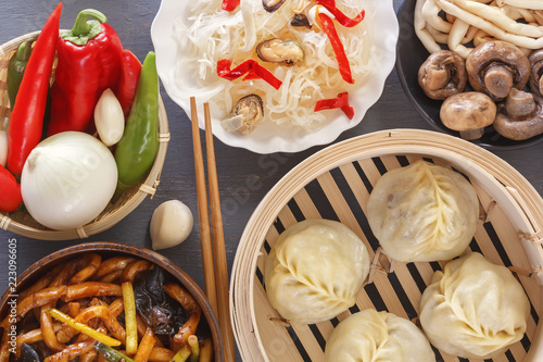 Dishes of Chinese cuisine in assortment. Steam dumplings, noodles, salads, vegetables, mushrooms, seafood. Top view. Close-up