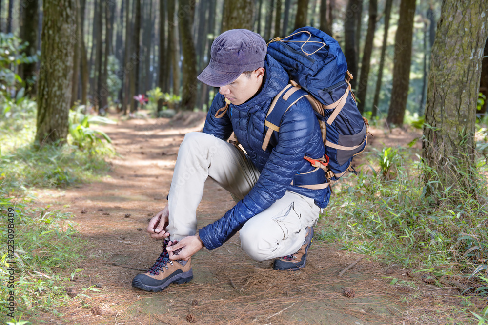 Portrait of asian traveler man tying shoelace before explore Portrait of asian traveler man tying shoelace before explore