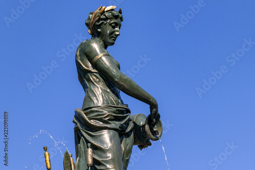 statue of goddess on fountain closeup blue sky background