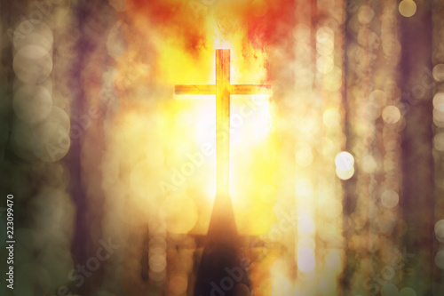 silhouette of burning cross with rays of sunlight background