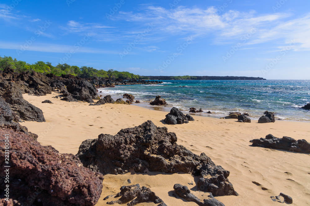 lava rocks on sandy ocean beach