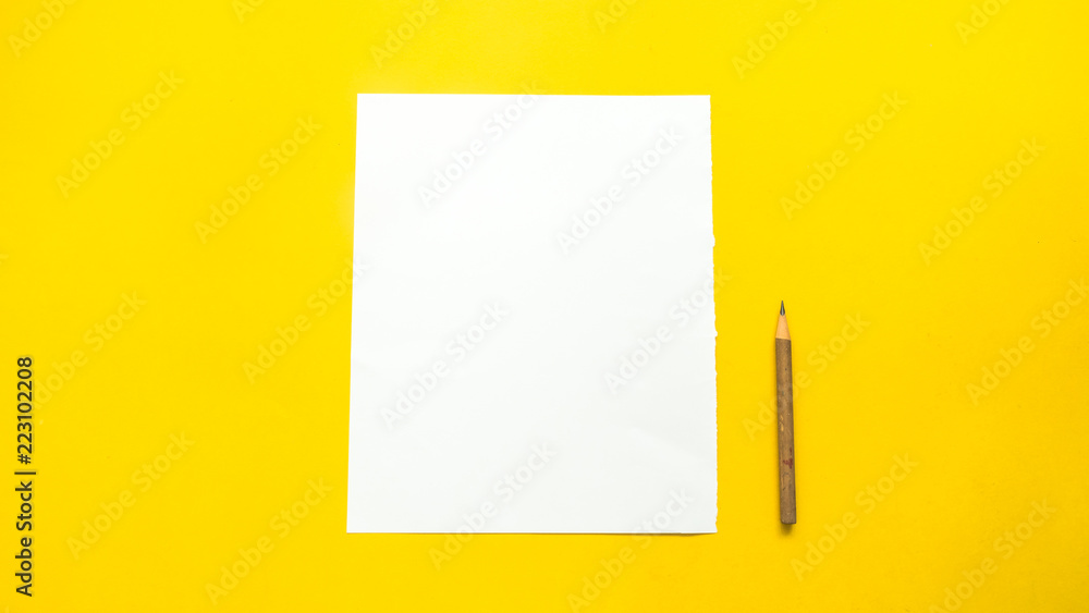 Paper and pencil on yellow background Paper and pencil on yellow background