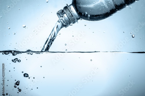 Water Pouring out of Plastic Bottle on the Light Blue Background
