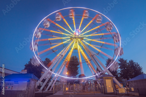 Ferris wheel in motion against the blue sky