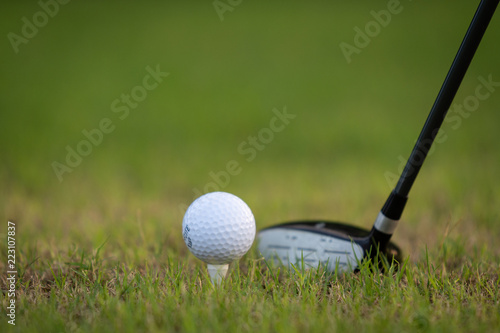 Three metal wood at rest behind teed-up golf ball providing copy space for text or graphics.