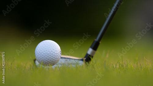 Three metal wood at rest behind teed-up golf ball providing copy space for text or graphics.