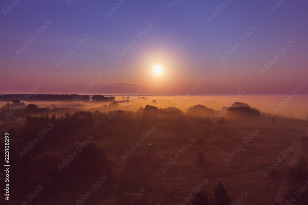 Landscape at sunrise with sunshine in the fog