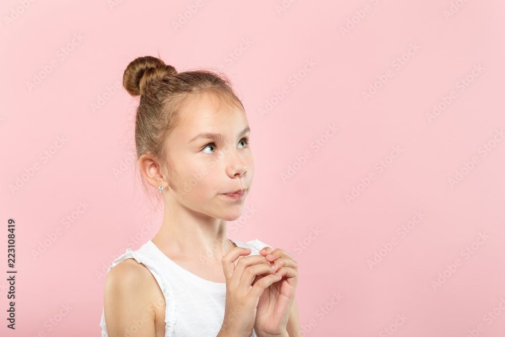 cute pretty young girl looking up at a virtual object or text speech bubble. empty space for advertising. portrait of a child on pink background. cute pretty young girl looking up at a virtual object or text speech bubble. empty space for advertising. portrait of a child on pink background.