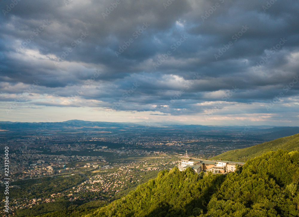 Fototapeta premium Aerial photograph of Sofia TV tower, Bulgaria - amazing scenery under the golden light of the setting sun with dark and moody skies