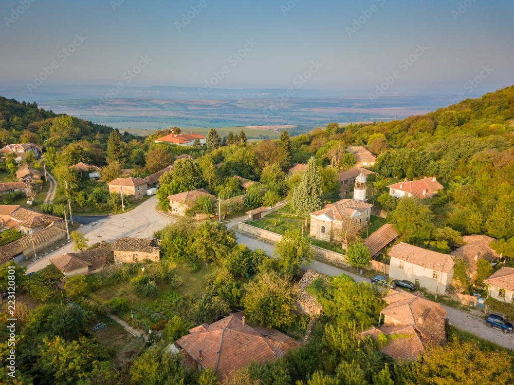 Aerial shot of a small mountain village in Bulgaria - typical rural scenery, beautiful sunrise
