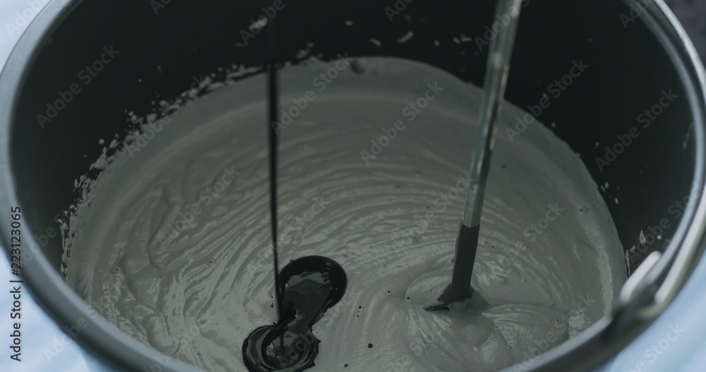 Fototapeta premium adding black ink to micro concrete plaster
