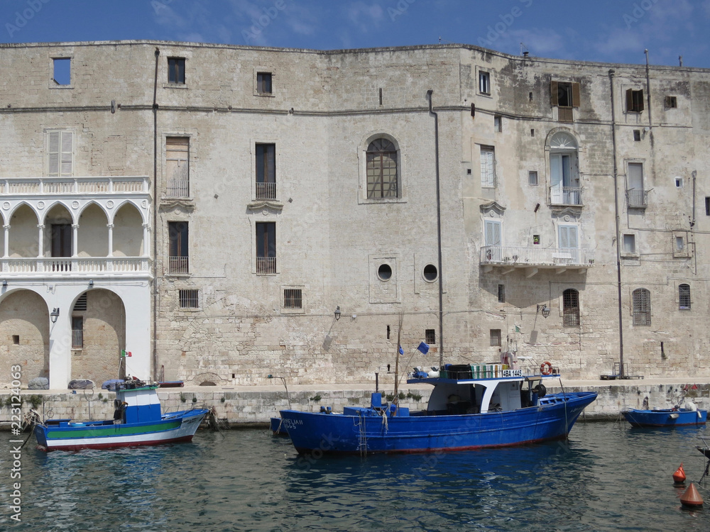 facade and quay in Polignano a Mare with boats and fishing gear
