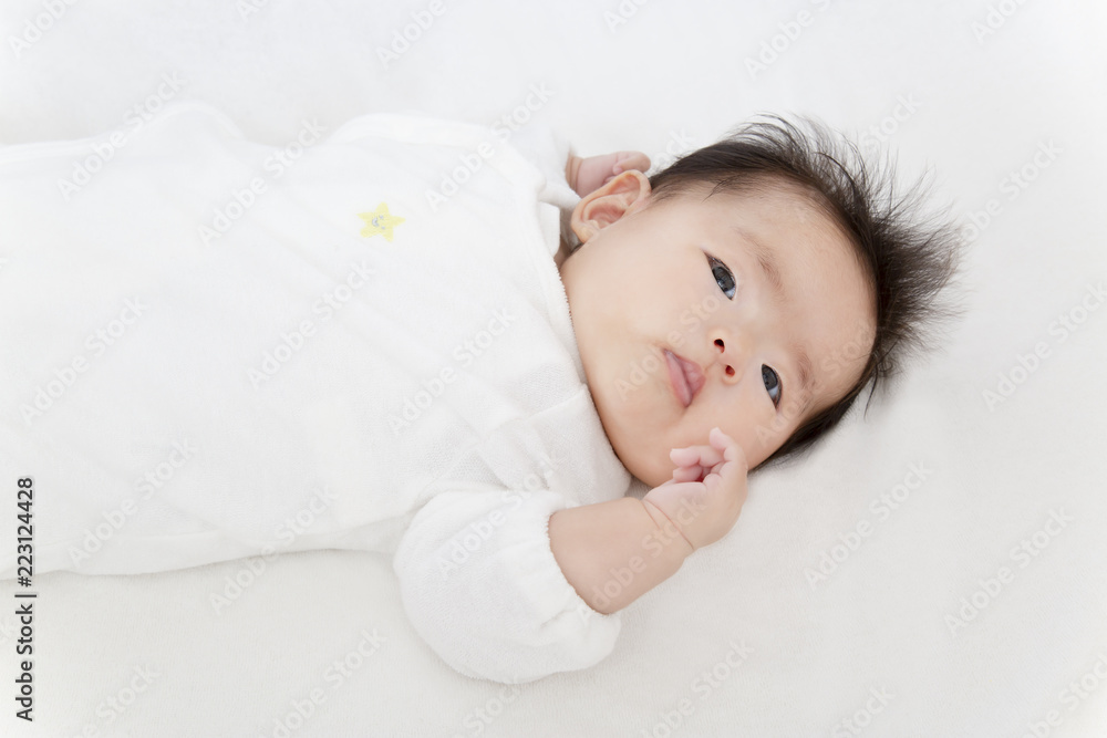 白いオーバーオールを着てカメラ目線の生後3ヶ月になった新生児。新生児、赤ちゃん、育児、健康のイメージ 白いオーバーオールを着てカメラ目線の生後3ヶ月になった新生児。新生児、赤ちゃん、育児、健康のイメージ