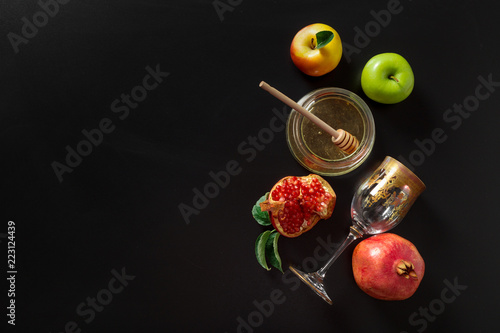 Pomegranate, apple and Honey for traditional holiday symbols Rosh hashanah (jewish new year holiday) on black background