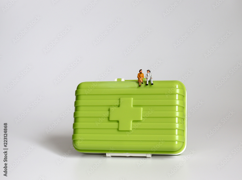 Obraz premium A miniature old couple sitting on a green medicine chest.