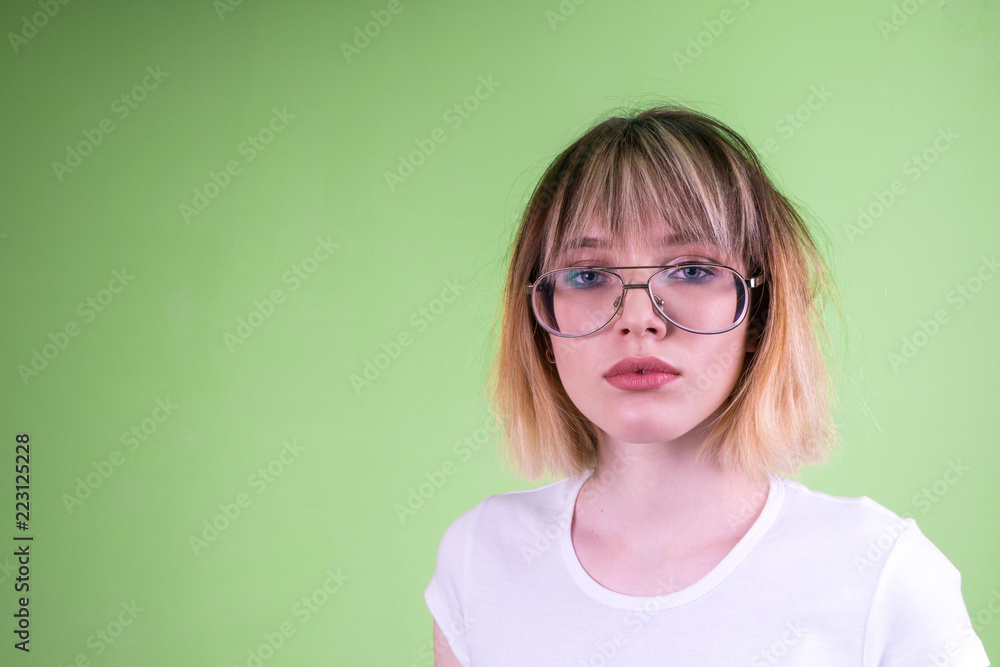 Portrait of a beautiful girl in glasses with short blond hair.