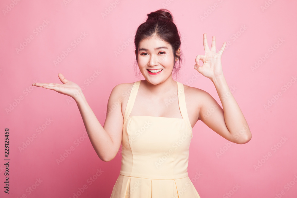 Beautiful young Asian woman show palm hand and OK sign. Beautiful young Asian woman show palm hand and OK sign.
