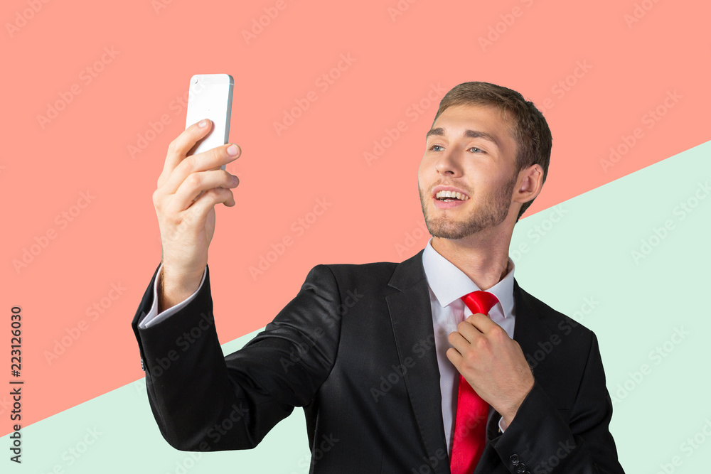 Handsome young businessman taking a selfie with a mobile phone