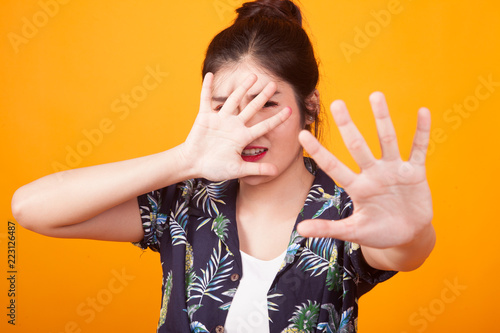 Young Asian woman hide her  face in tropical shirt